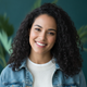 Headshot of a smiling North American woman in her late 20s, conveying trust and satisfaction.